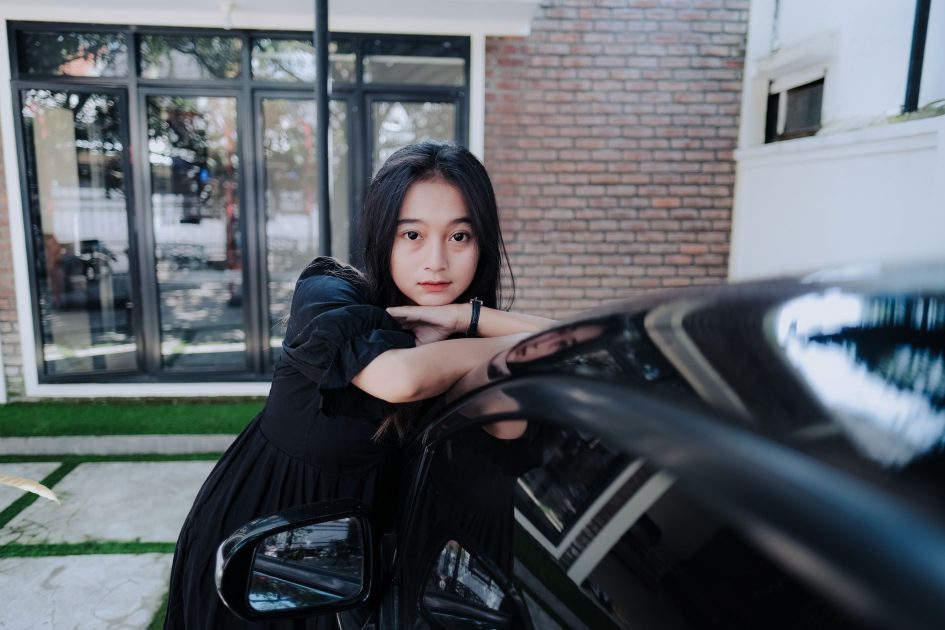 Haru Wanita Nikahi Kekasihnya Idap Kanker: 7 Panduan Lengkap 1 A young woman in a black dress leans against a car in an outdoor setting.