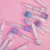 Top view collection of blood test tubes with stickers and colorful caps scattered on pink background