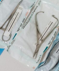 Close-up of sterilized surgical tools in packaging on a clinical table.