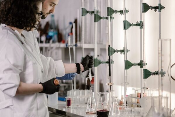 Scientists in lab coats work with test tubes in a modern laboratory.