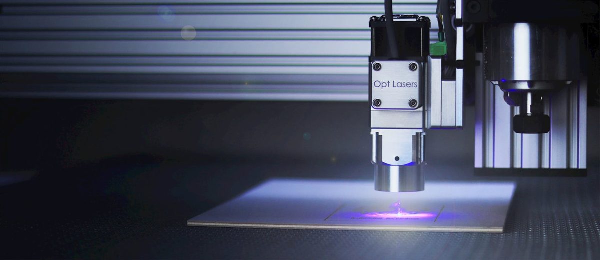 Electron Beam Evaporation System: Panduan Lengkap 2024 1 Close-up of a laser engraver working on a surface under blue lighting.