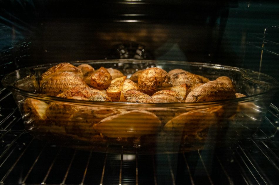 Glass Baking Oven: Pengertian, Fitur & 5 Aplikasi Utama 1 Through glass of appetizing unpeeled spicy potatoes in dish roasting in oven at home