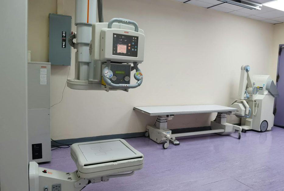 INNOVISION-DXII UNIVERSAL: 7 Fitur Unggulan X-Ray 2025 1 Clinical setting with X-ray machines and examination table in a healthcare facility.