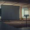 Spacious modern office interior featuring a projector and screen for presentations.