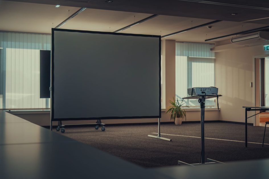 Lensa Proyektor VPLL-2007 - Michael Pointner Spacious modern office interior featuring a projector and screen for presentations.