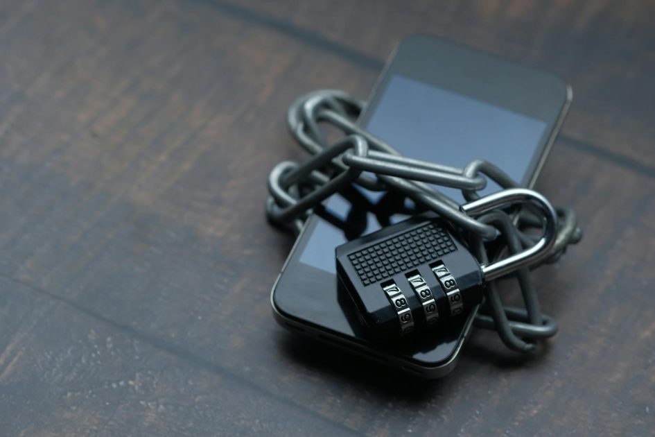 Mobile Shield: Panduan Lengkap Keamanan Perangkat 2024 1 Close-up of a smartphone wrapped in a chain with a padlock, symbolizing strong security.
