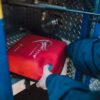 Modul Bahasa AED Trainer PRESTAN | Inggris-Spanyol 1 Close-up of an emergency defibrillator being placed in a fire truck compartment.
