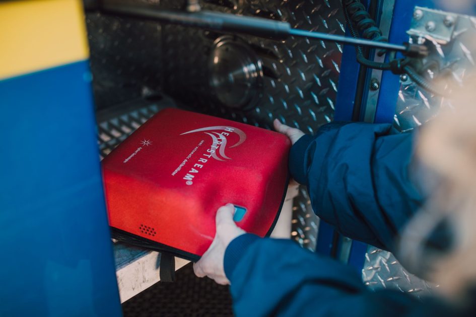 Modul Bahasa AED Trainer PRESTAN - RDNE Stock project Close-up of an emergency defibrillator being placed in a fire truck compartment.