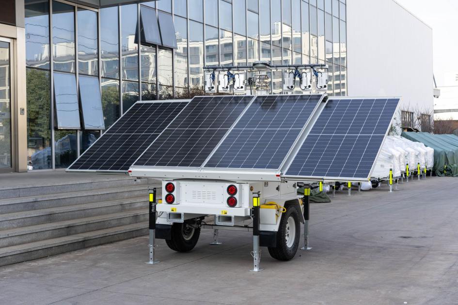 Portable Solar Simulator PEC-L01: Panduan Lengkap 2024 1 A mobile solar panel trailer parked outdoors by a modern building, showcasing renewable energy technology.