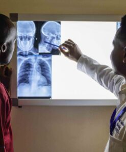 A doctor reviews X-ray images with a patient in a medical facility, highlighting healthcare interaction.