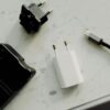 Flat lay of electronic adapters and chargers on a marble background.