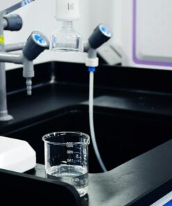 Close-up of laboratory equipment used for water filtration, featuring beakers and faucets.