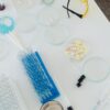 Aerial view of laboratory equipment including petri dishes, pills, test tubes, and syringes.