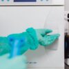 Close-up of operator using sterilization machine in a medical facility.