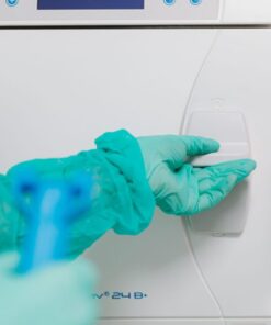Close-up of operator using sterilization machine in a medical facility.