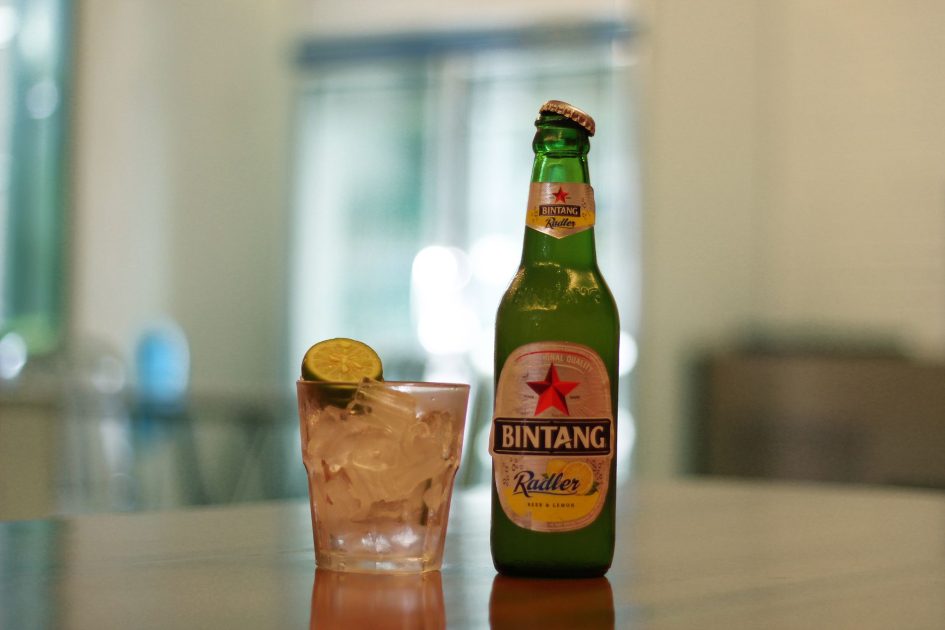 10 Kriteria Beri Rating Diet Bintang Sepakbola: Panduan Sehat Ala Atlet Profesional 1 Bintang Radler beer bottle and iced lemon drink on a reflective surface indoors.