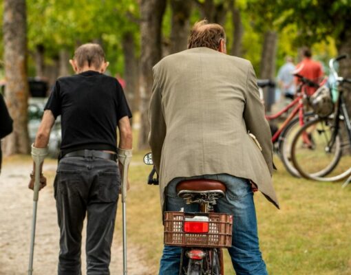 Elderly men walking and cycling in Kuressaare park, fostering companionship.