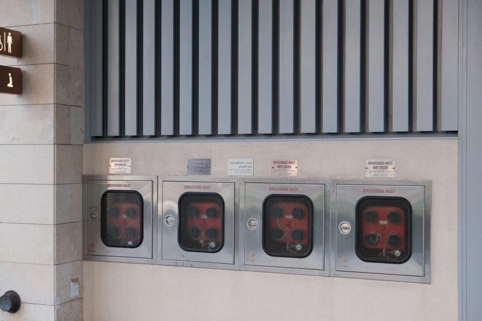 Breeching inlets for fire safety at a Dubai metro station, highlighting modern architecture.