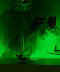 A scientist in protective gear works with glassware in a green-lit laboratory, evoking mystery and scientific exploration.