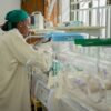 Doctor attending to newborns in an incubator in a hospital neonatal unit.