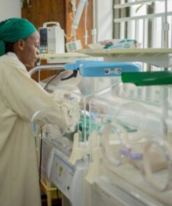 Doctor attending to newborns in an incubator in a hospital neonatal unit.