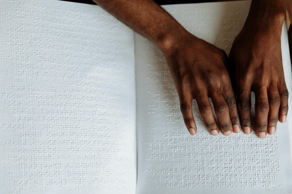 Influencer Cosplay Jadi Disabilitas Banjir Kritik: 5 Fakta Penting 1 Close-up of hands reading a Braille book, highlighting tactile sensory perception for the visually impaired.