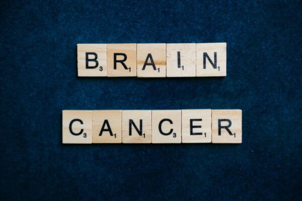 Wooden tiles spelling 'Brain Cancer' on a dark blue background, symbolizing awareness.