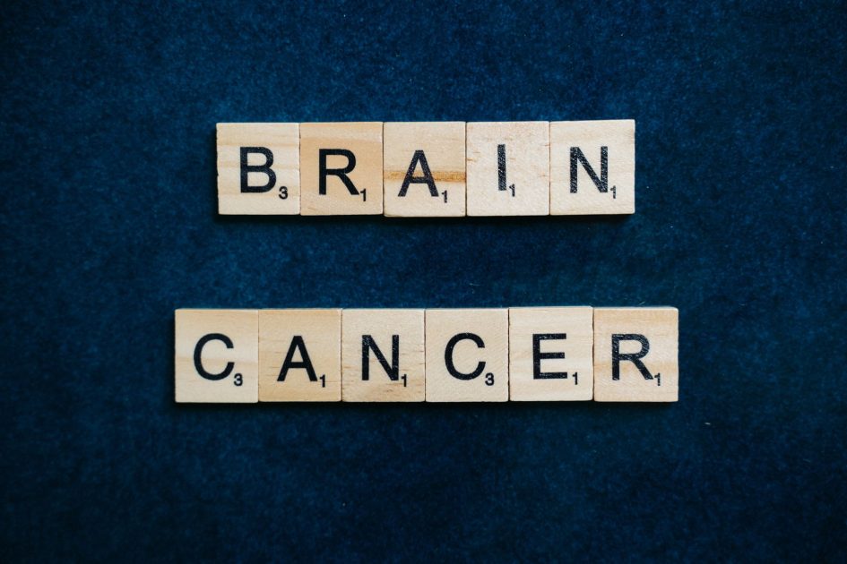 Wooden tiles spelling 'Brain Cancer' on a dark blue background, symbolizing awareness.