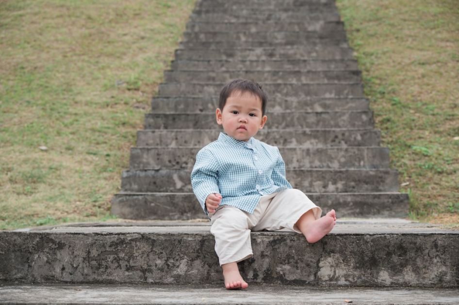 a little boy sitting on a set of stairs