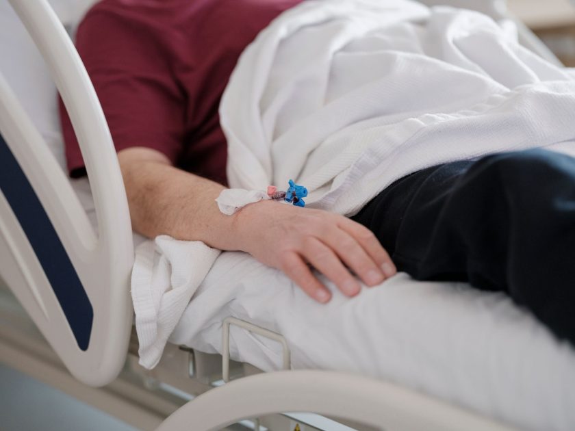Kisah Pria Palu Kena Gagal Ginjal: 7 Pelajaran Penting 1 Close-up of a patient's hand with an IV drip lying on a hospital bed.