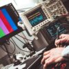 Technician operating laboratory electronic testing and measurement devices with colorful display.