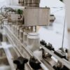 Mesin Kemasan Karton Otomatis untuk Botol XZBP | Hualian 2 Close-up of an automated can filling machine in a beverage production line.