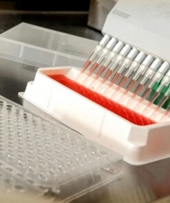 Close-up of an automated pipetting system dispensing liquids in a scientific laboratory.