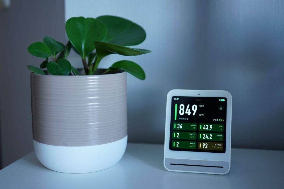 mobile air cleaner medis - Tim Witzdam Air quality monitor next to a potted plant on a desk, showing CO2 and PM2.5 levels.
