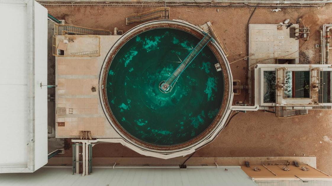 7 Kegunaan Multi-Media Filter & Activated Carbon Filter 1 Drone view of a large circular water treatment tank at an industrial facility.