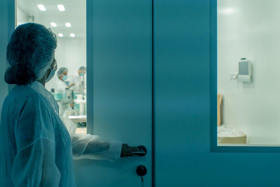 7 Langkah Perawatan Cargo Air Shower yang Wajib Diketahui 1 A scientist in protective gear enters a sterile laboratory environment, ensuring cleanliness.