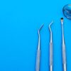 Periodontal Instruments ASA Dental 1804-2 | Alat Bedah Gingiva 1 Close-up of stainless steel dental tools arranged on a bright blue surface, showcasing various instruments.
