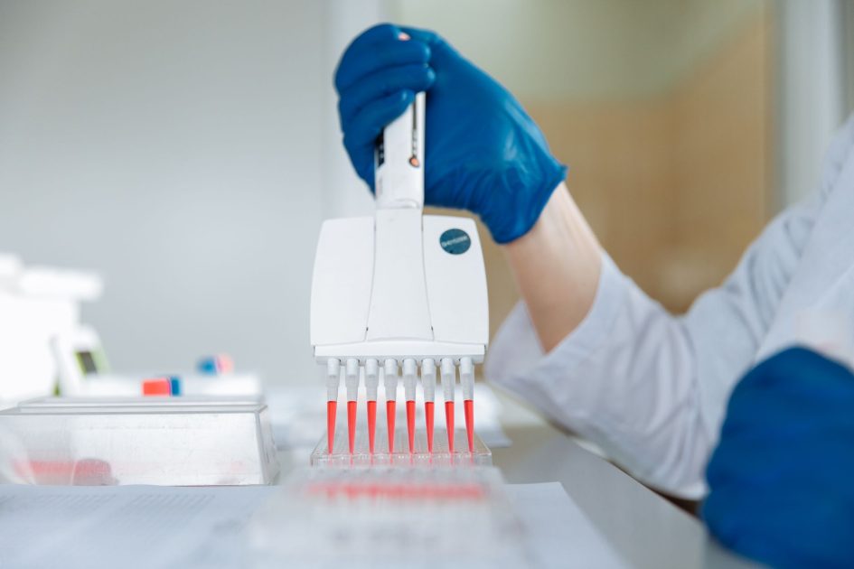 pipettor 8 channel Corning Lambda Plus - Thirdman Close-up of a lab technician using a multichannel pipette for testing in a laboratory.