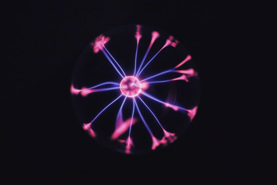 Aplikasi Plasma System: Panduan Lengkap & 7 Manfaatnya 1 Transparent glass plasma ball with bright neon luminous against dark background in room