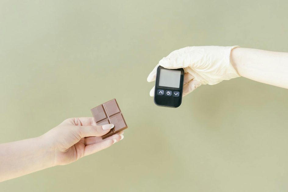 Nitrile vs Latex vs Vinyl: 7 Faktor Penentu Sarung Tangan Terbaik 1 Close-up of hands holding a chocolate bar and glucose meter.