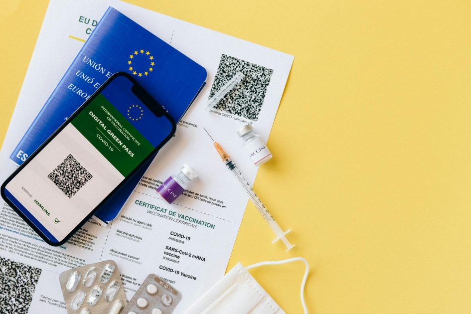 Cara Cek Sertifikasi Alkes Kemenkes: Panduan Lengkap 2025 1 Digital vaccine passport and COVID-19 vaccination items including syringes and masks on a yellow background.