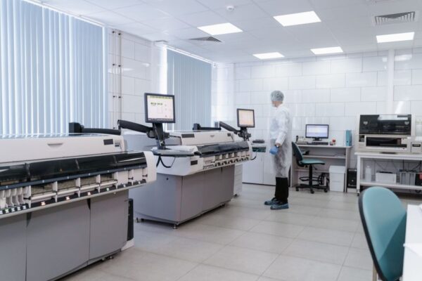 Scientist in a modern laboratory analyzing data on advanced equipment and monitors.