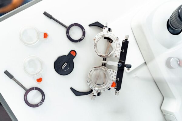 High-angle shot of optometry trial frames and lenses on a white surface.