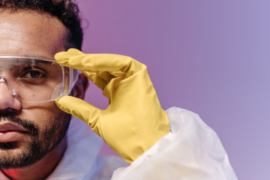Erlab Isolation Enclosure Portable Glove Bag Lab Terbaik 2026: 7 Panduan Lengkap 1 Close-up of a scientist adjusting goggles while wearing protective gear in a laboratory setting.