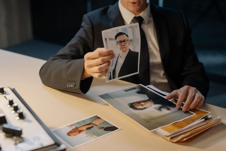 Investigasi Internal Kemenkes Ada Dugaan: 9 Fakta Penting 2025 1 A detective in a suit reviews evidence photographs at a table, highlighting a crime investigation scenario.