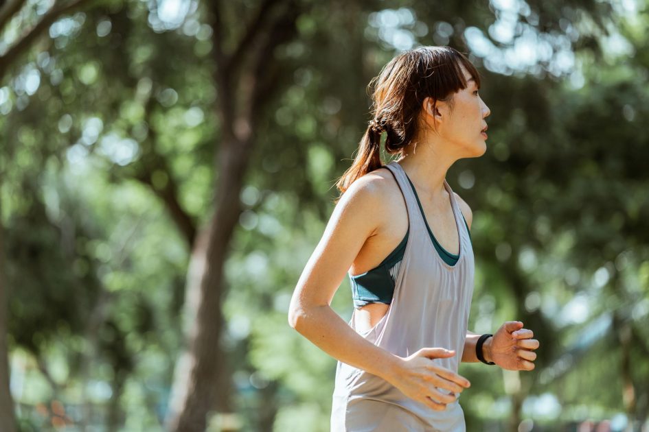 Langkah Kecil Berdampak Besar: 7 Kebiasaan Sehat Gen Z 2024 1 Side view of determined focused Asian female runner in sportswear jogging in green lush park on sunny morning