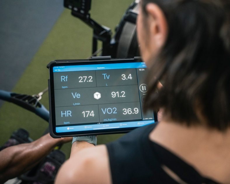 Menguak Pola Diet Harry Kane: 7 Rahasia Nutrisi Striker Terbaik 1 Adult man reviewing fitness metrics on a tablet during a workout session at the gym.