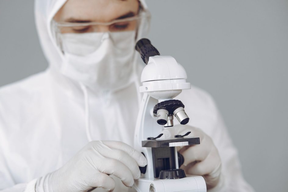 Particle Analyzer Farmasi: 5 Metode & Kapan Gunakan 1 Medical professional in protective gear examining samples with microscope.