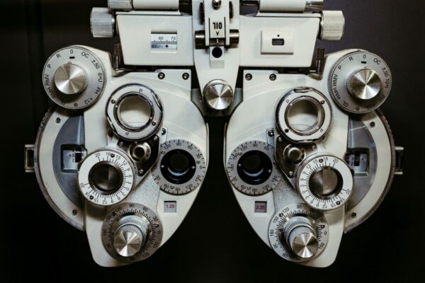 Detailed view of a vintage optometry phoropter with knobs and numbers, showcasing intricate technology.
