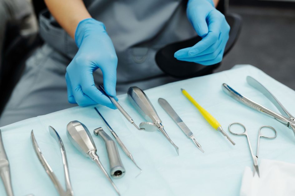 TTI Soroti Belanja Pemeliharaan Alat: Panduan Lengkap 2024 1 Close-up of gloved hands organizing dental tools in a clinical setting.